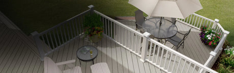 Terrasse extérieure en bois composite gris, mobilier de jardin, rambarde blanche et jardinières fleuries.